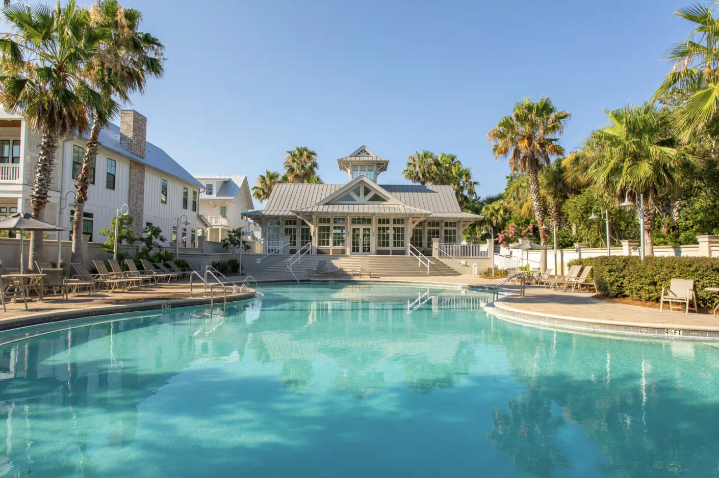 Resort-style community pool with palm trees and clubhouse